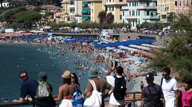 People sunbath and swim at the beach of Monterosso in the Cinque Terre National Park, near La Spezia, nortwestern Italy, on August 13, 2024. A UNESCO World Heritage Site since 1997 with almost 4,000 hectares of land, 130 kilometres of hiking trails, 5 villages, 4,500 hectares of Marine Protected Area and 4,000 inhabitants, the Cinque Terre (Five Lands) welcomed four million visitors in 2023, an increase of one million from 2022. (Photo by MARCO BERTORELLO / AFP) (Photo by MARCO BERTORELLO/AFP via Getty Images)